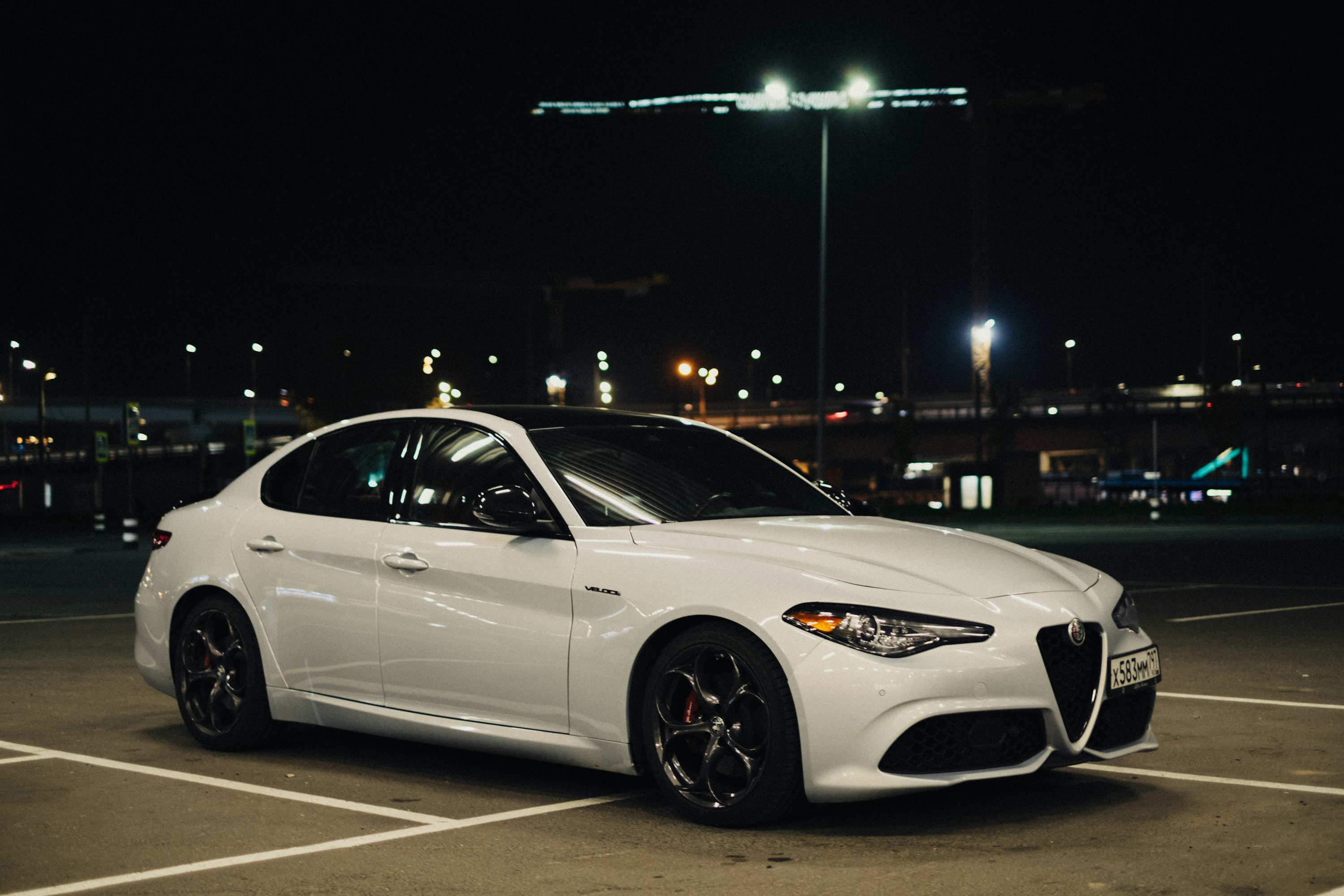 a white car parked in a parking lot at night