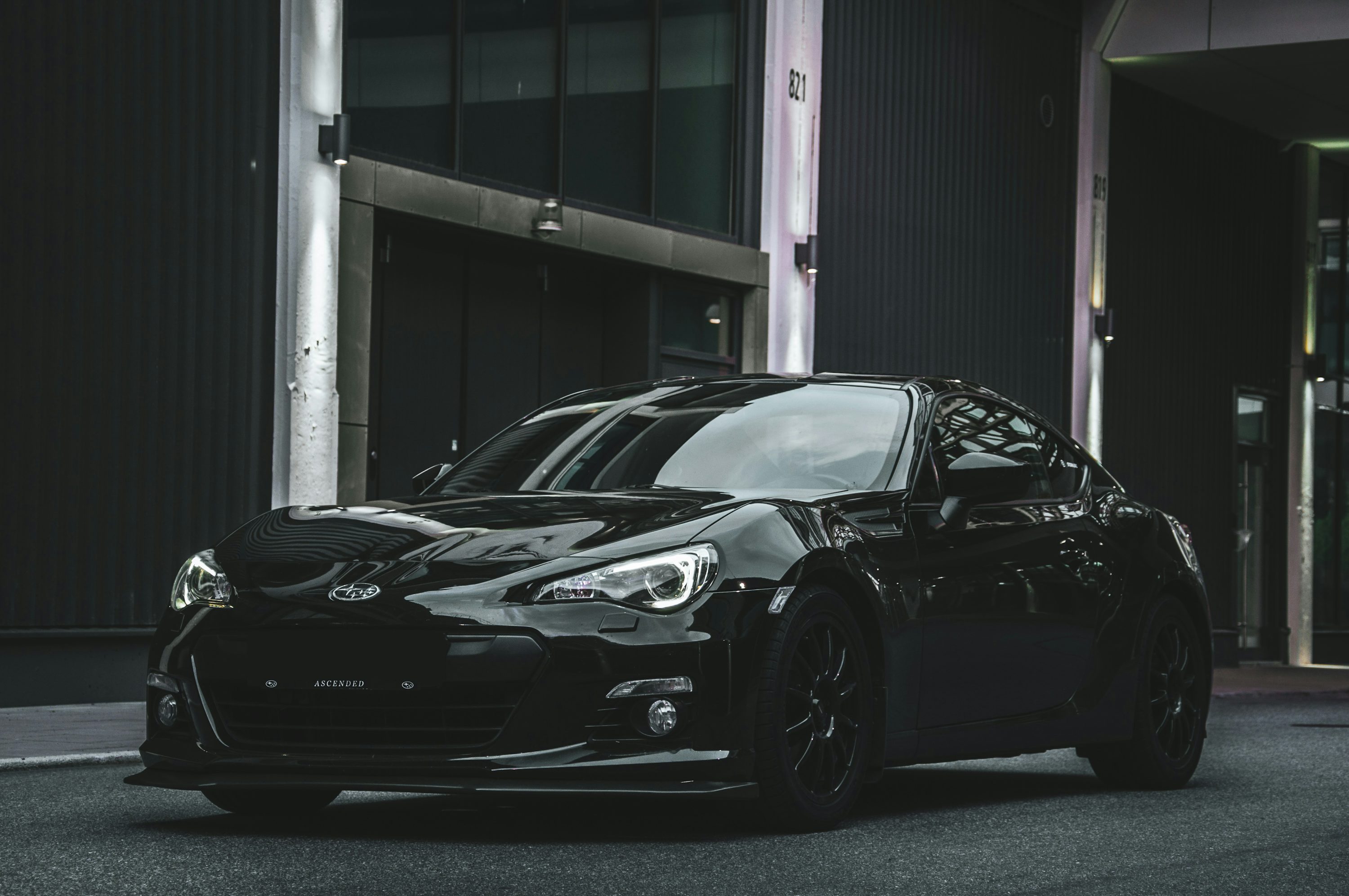 a black sports car parked in front of a building