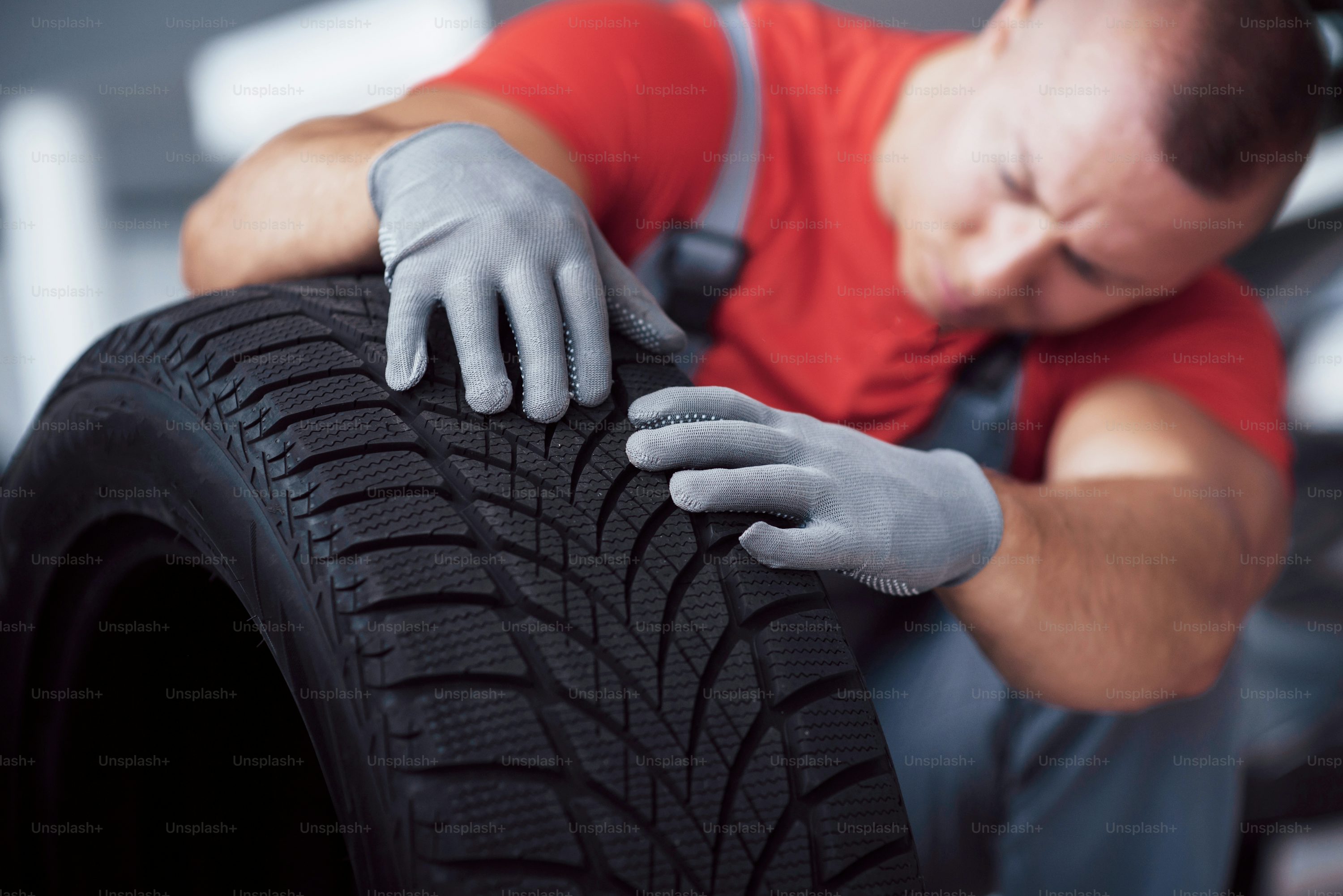 Mechanic holding a tire tire at the repair garage. replacement of winter and summer tires.