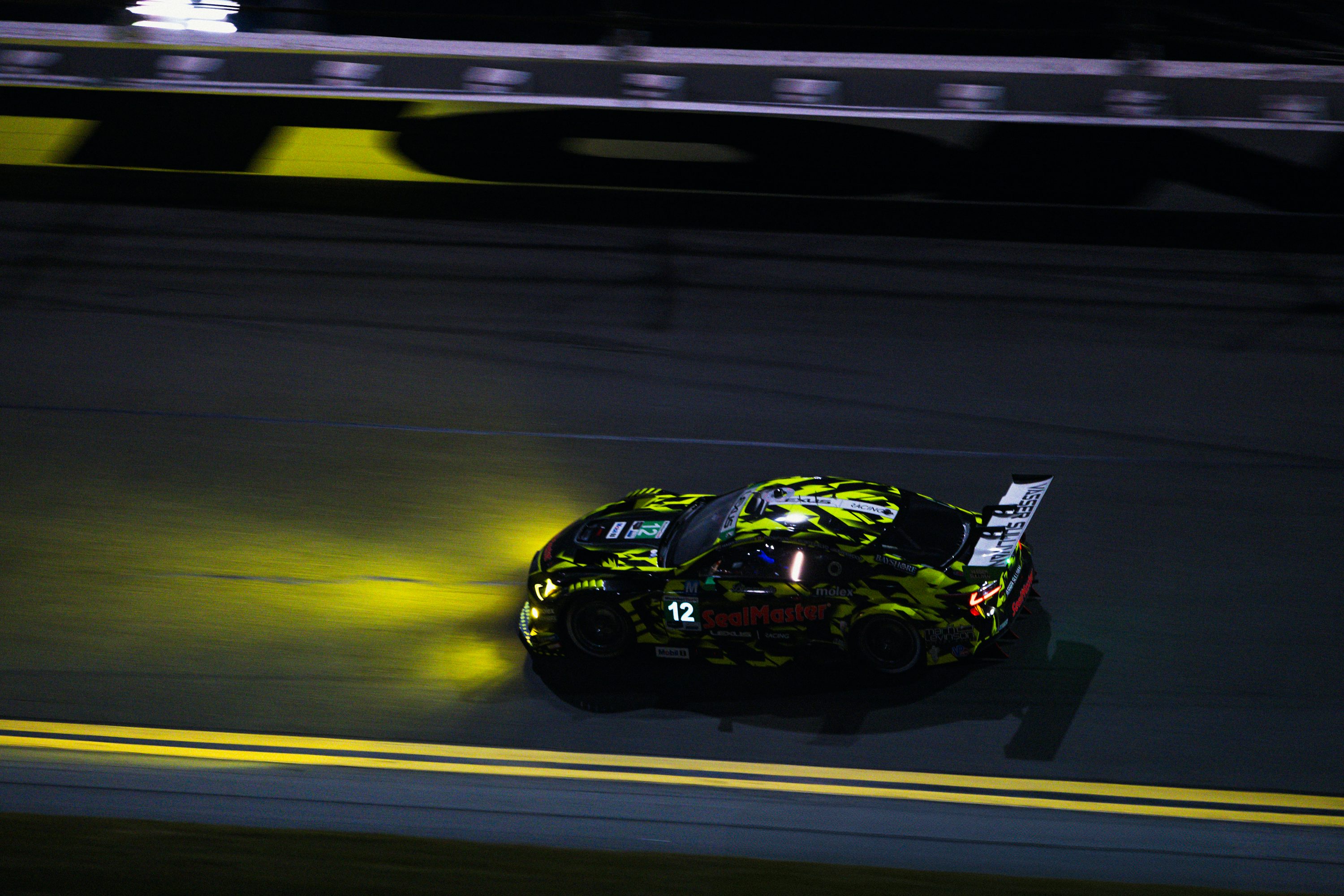 A car driving down a race track at night