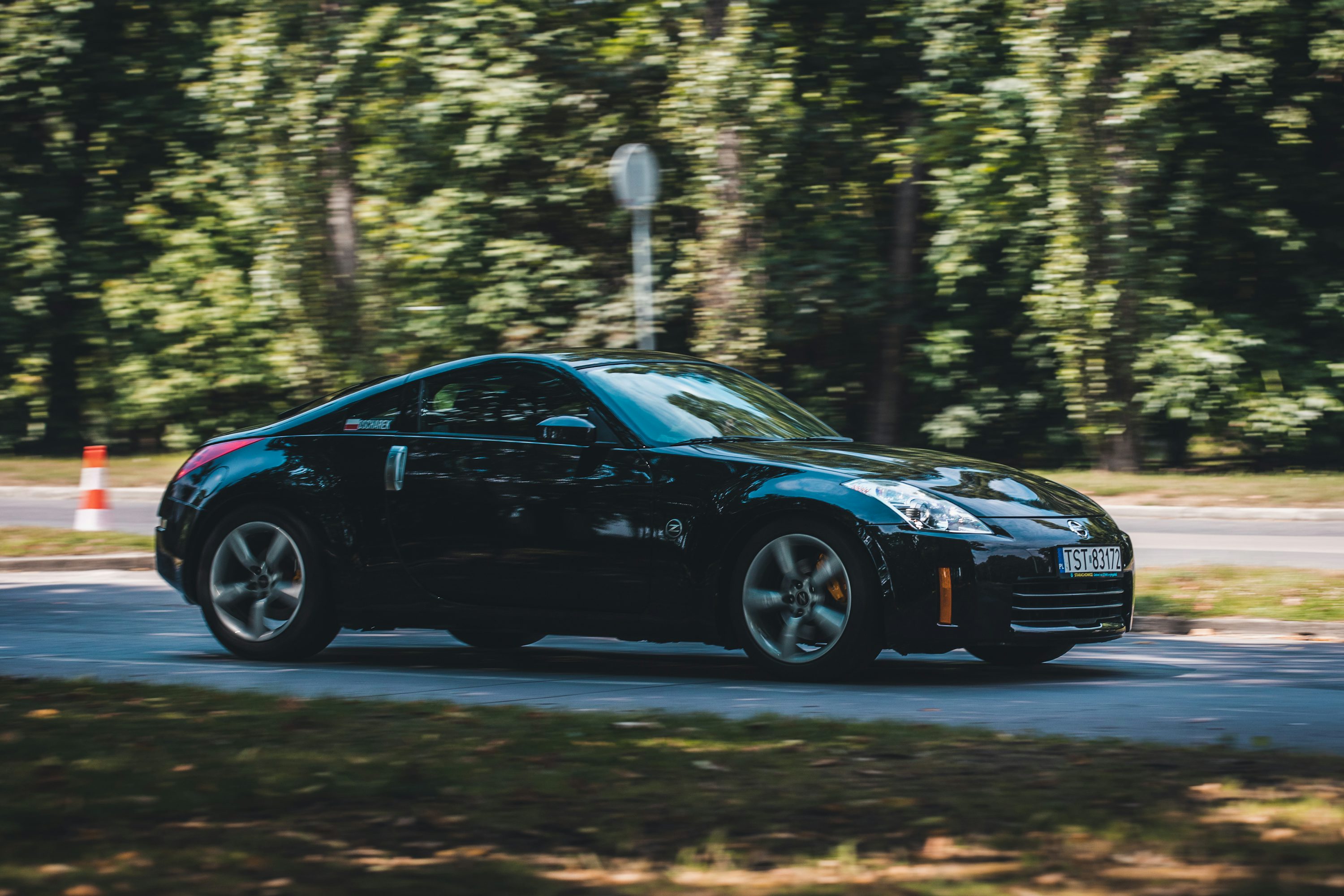 a black sports car driving down a street
