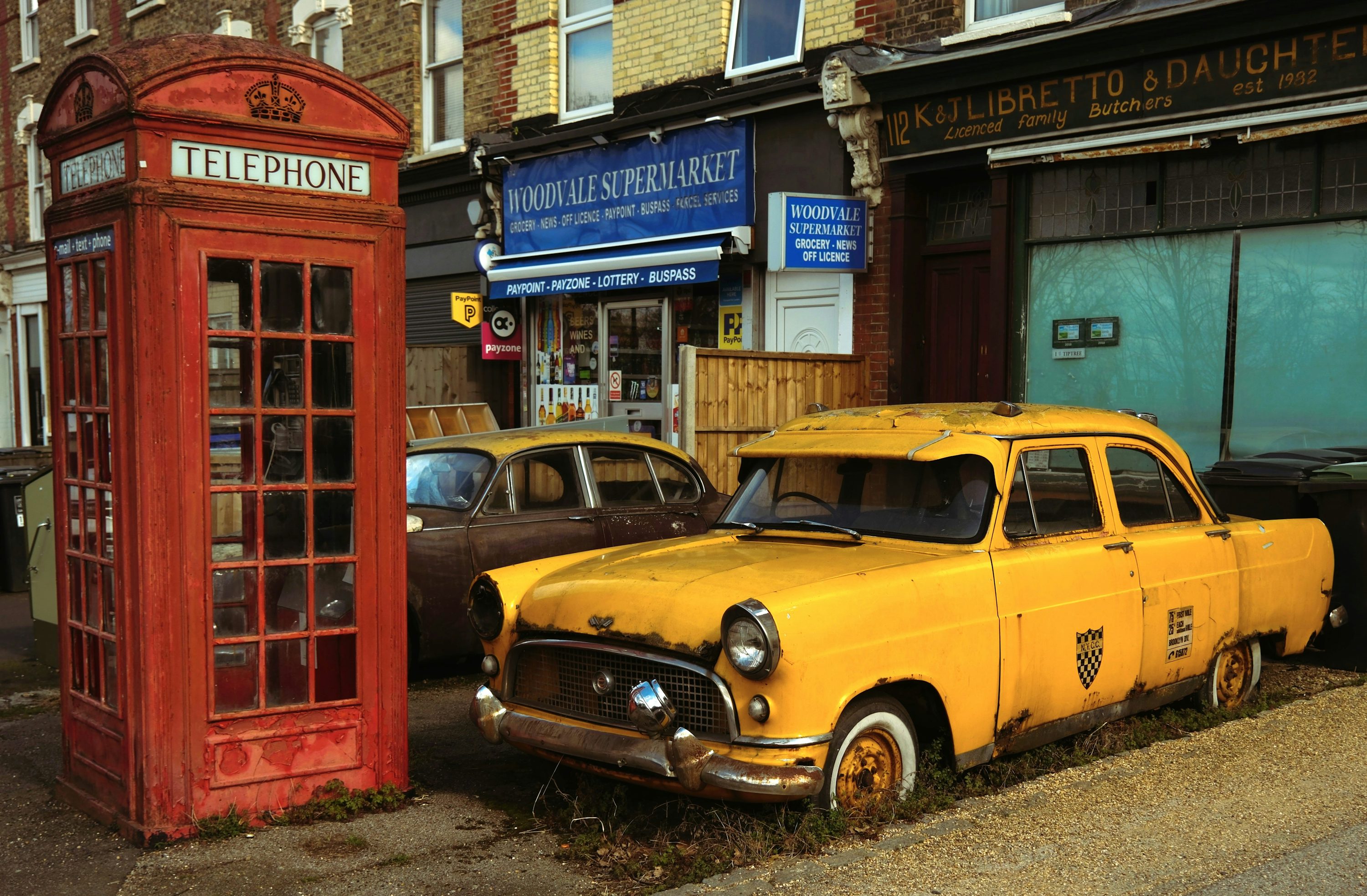 Red phone booth and vintage cars in england.