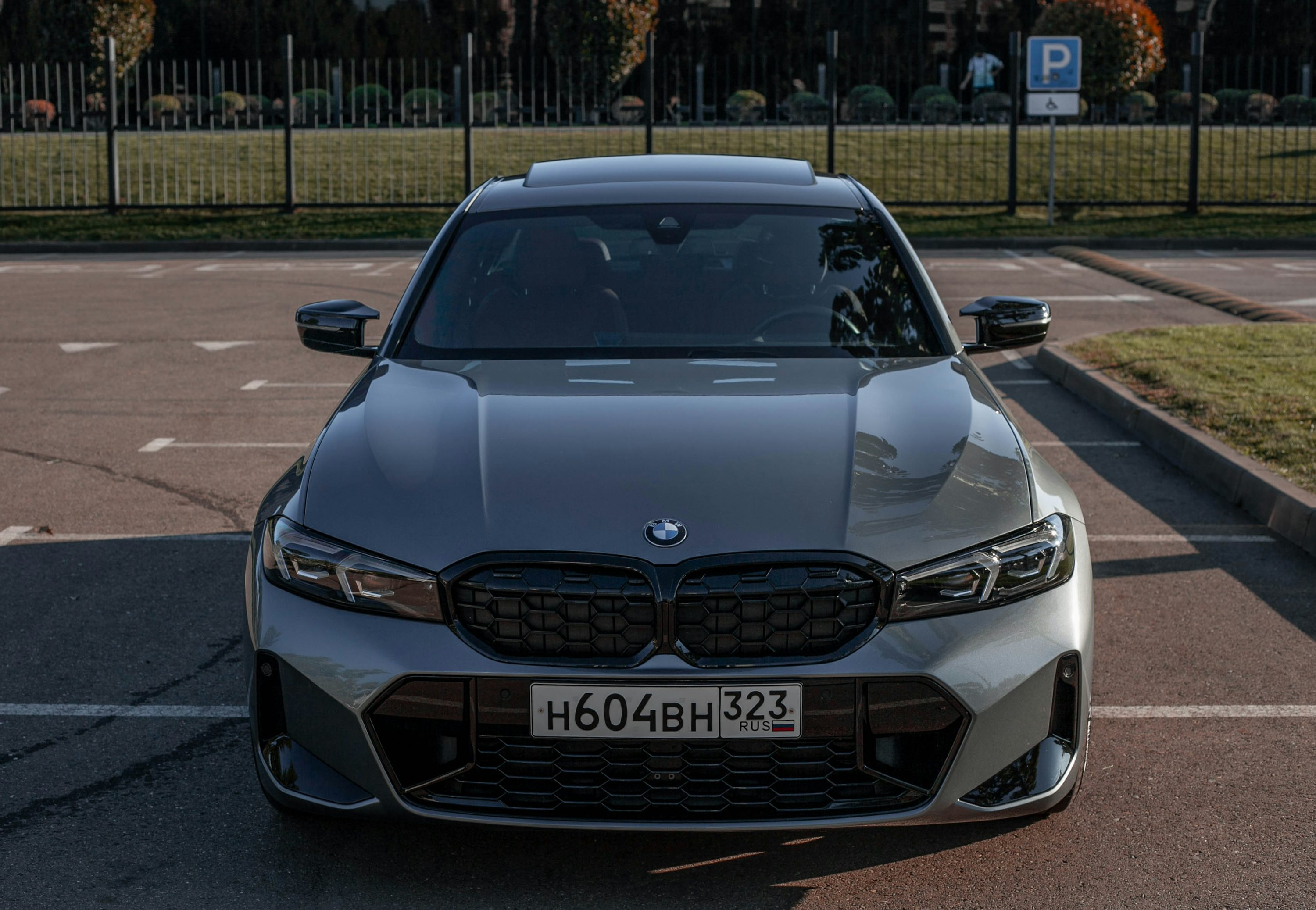 Front view of a grey BMW sedan parked outside.