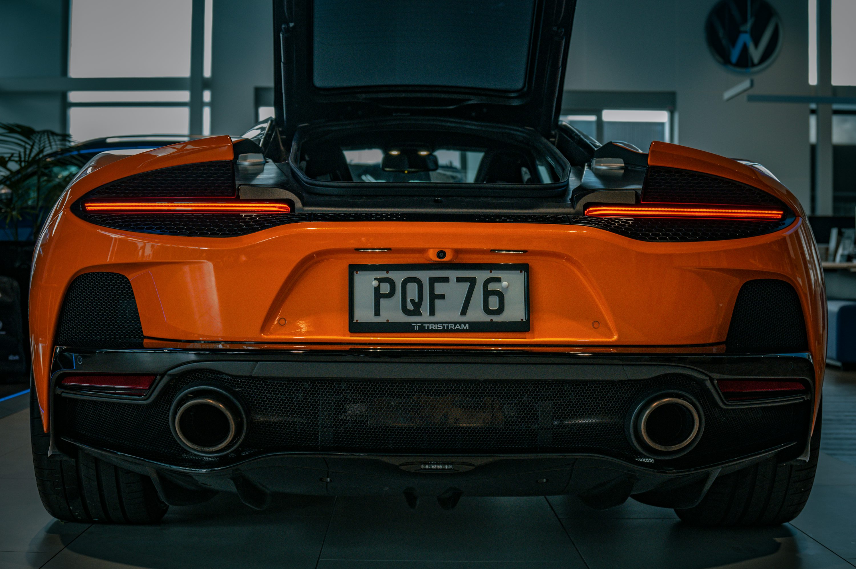 the rear end of an orange sports car