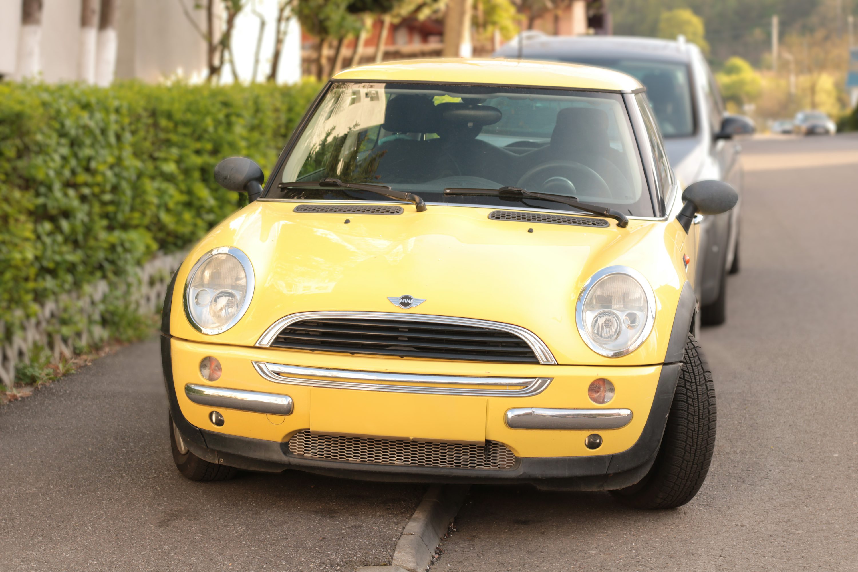 a small yellow car parked on the side of the road