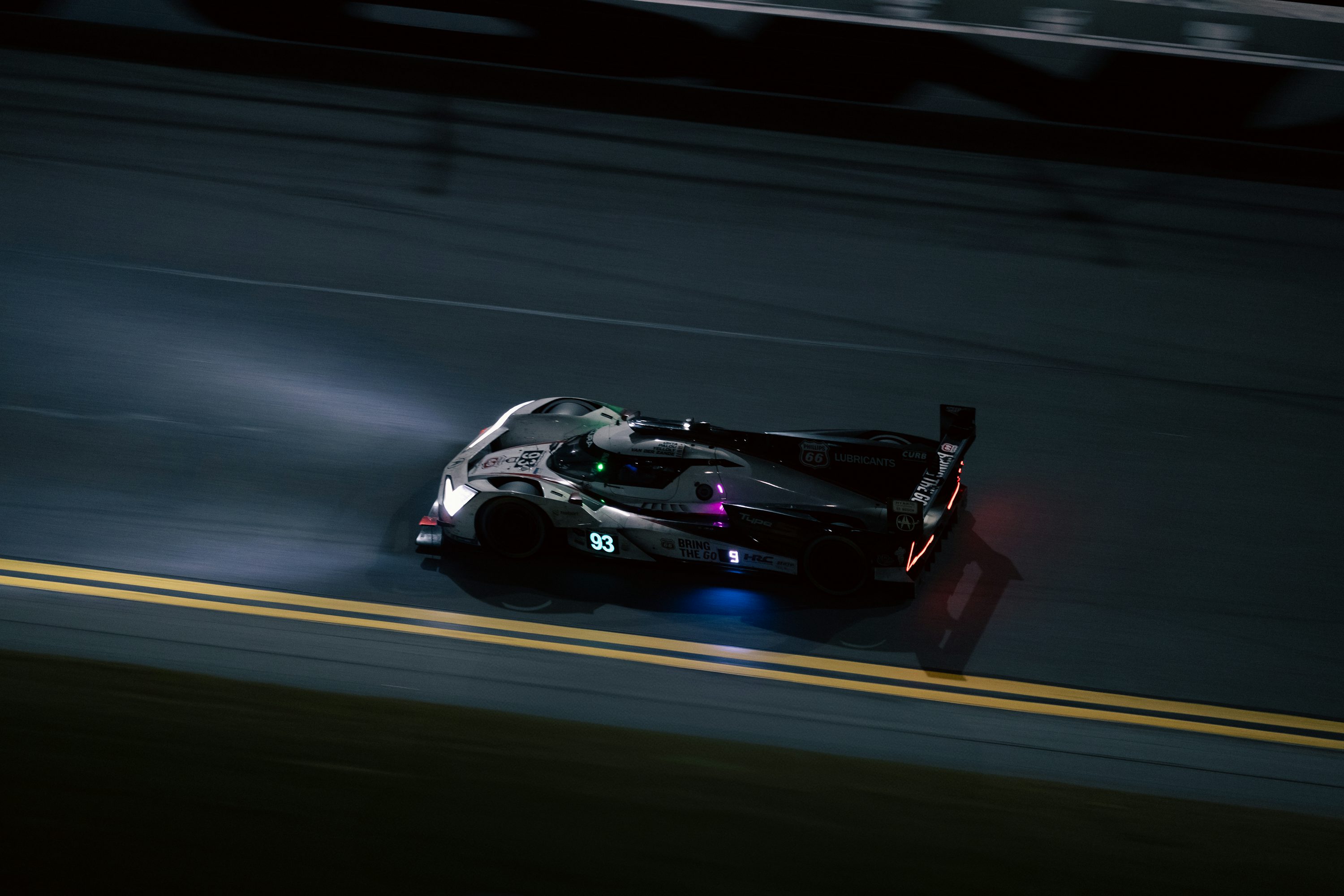 A car driving down a race track at night