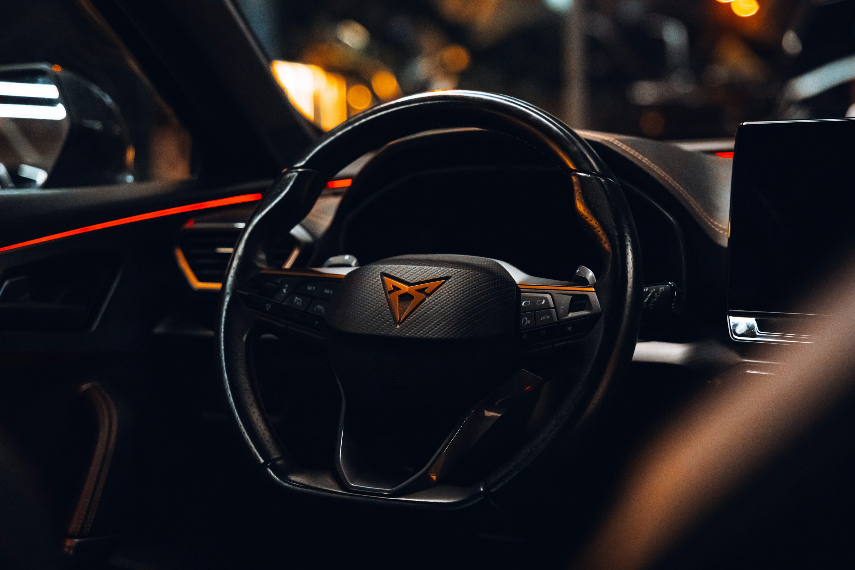 The interior of a car with a steering wheel and dashboard