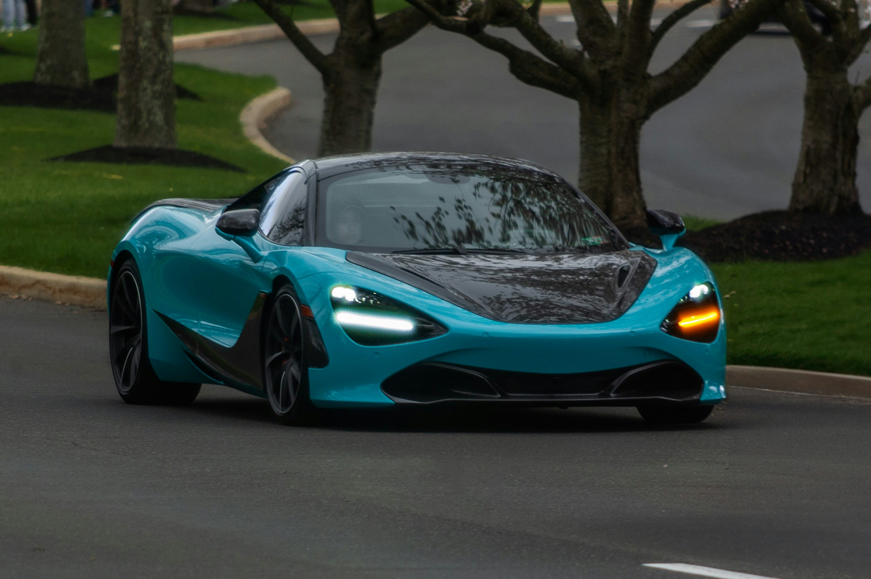a blue sports car driving down a street