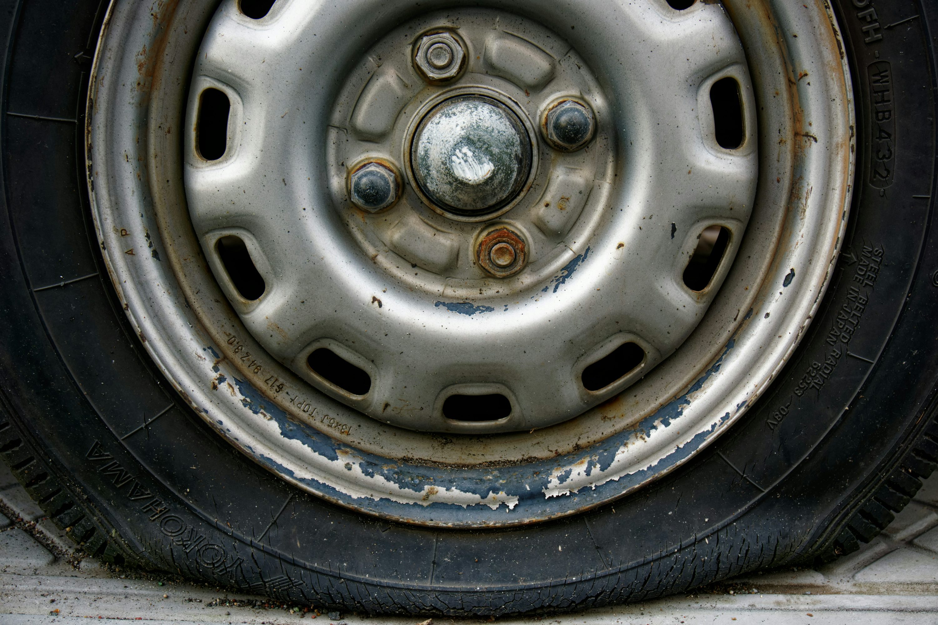 Close-up of a worn car tire and rim.