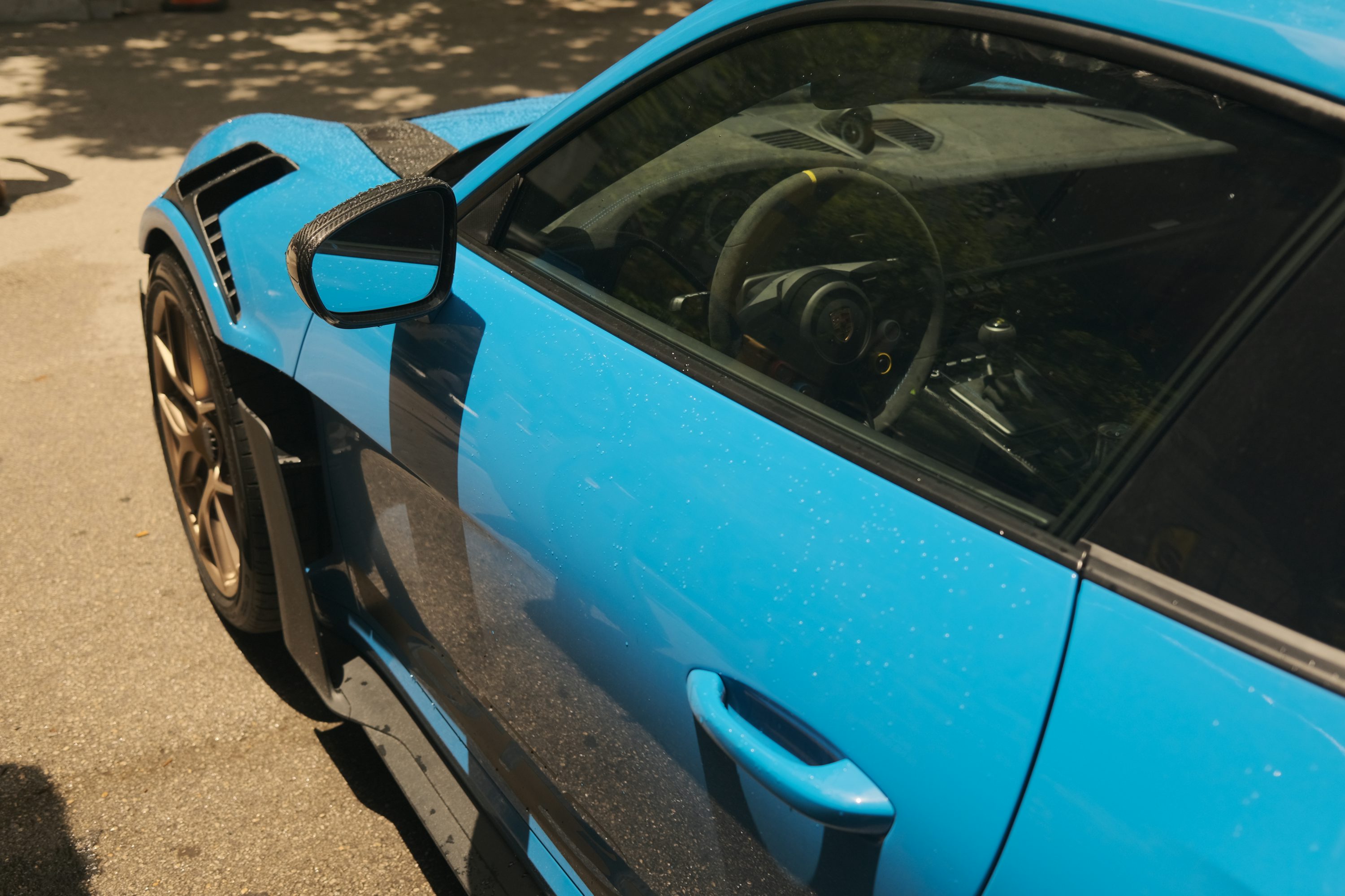 A blue sports car parked on the side of the road