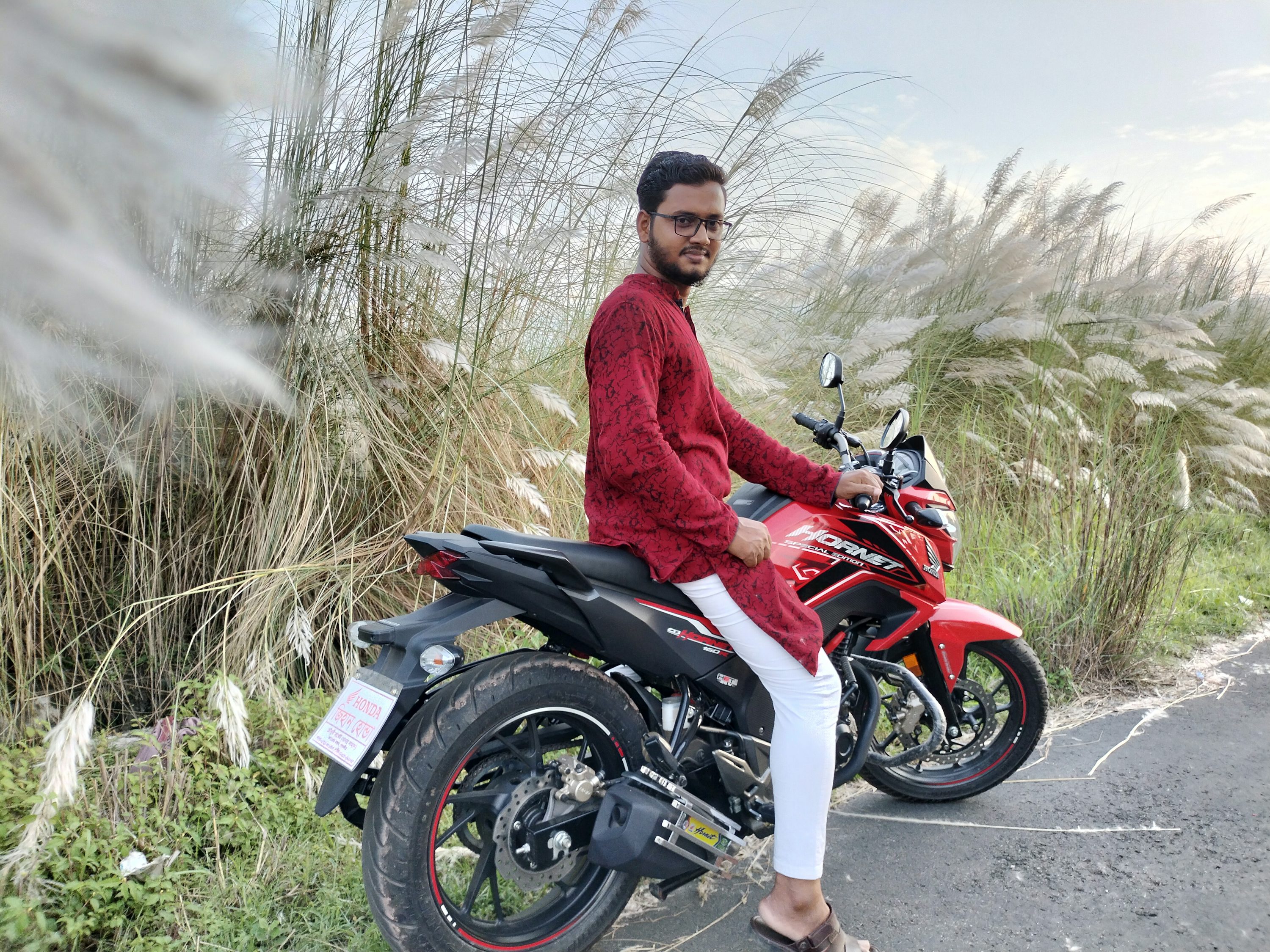 A man sitting on a motorcycle on the side of the road