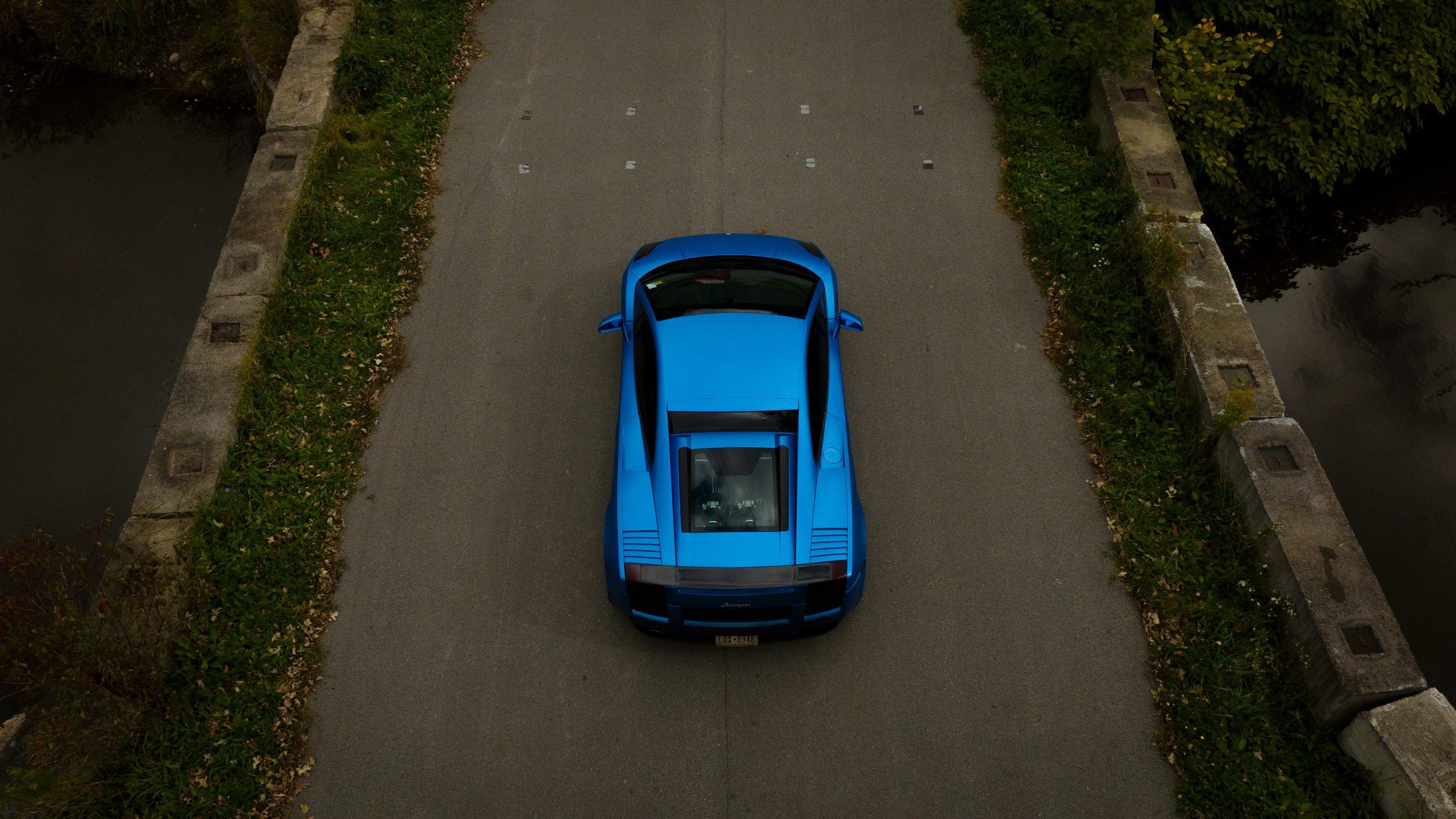 a blue sports car parked on the side of a road