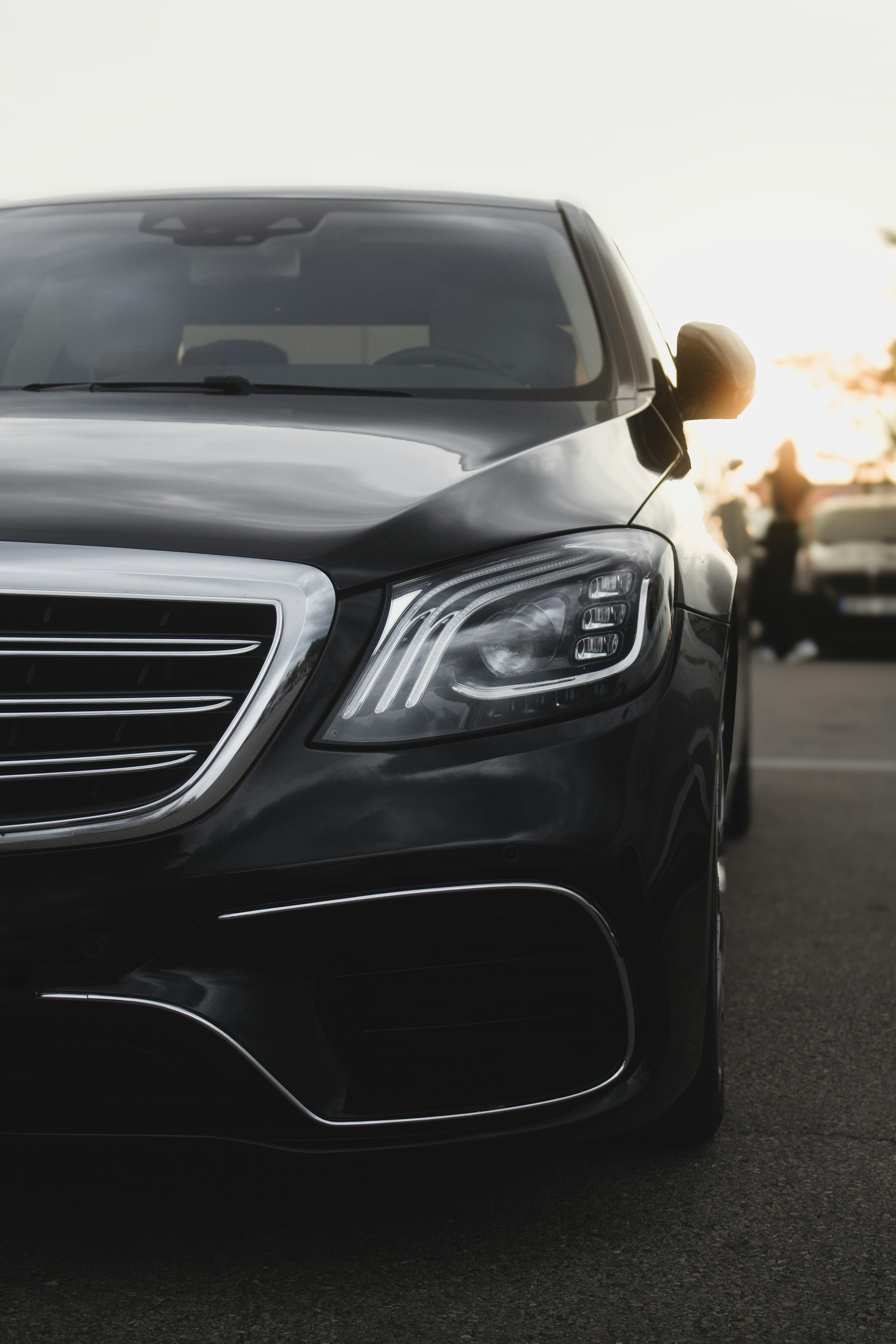 A sleek, black car gleams in the sunlight.