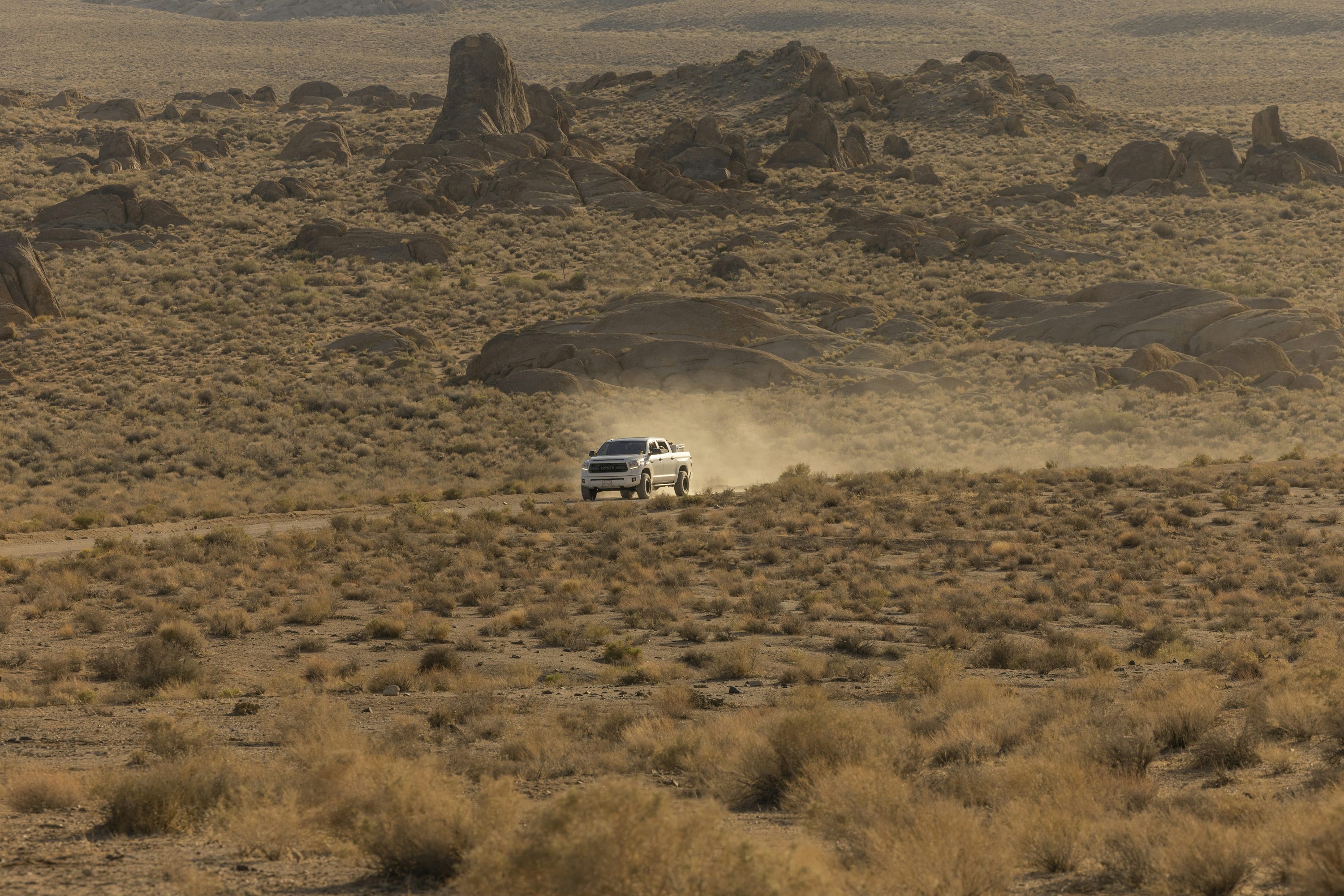 一辆白色卡车驶过沙漠景观